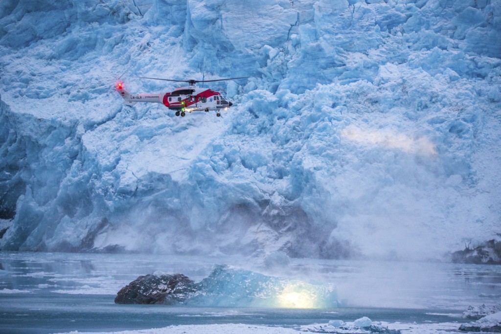 A helicopter flown by operator Lufttransport for the Govenor of Svalbard (Sysselmannen), flying in front of the Nordenskiold glacier. Using two AS332 L1 Super Puma helikopters they are tasked with Search and Rescue (SAR) and supporting the Governors office overseeing the Svalbard area.