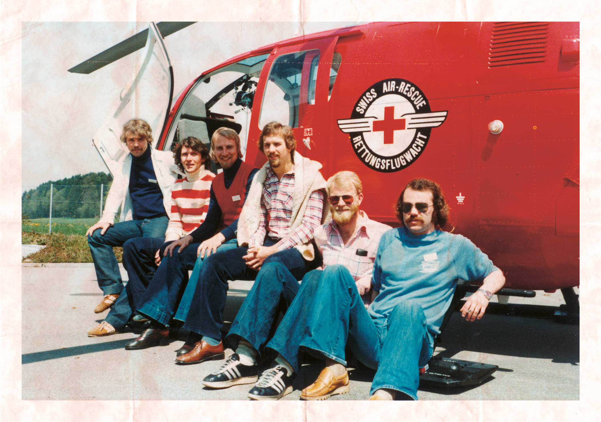 Seks nordmenn sitter foran sveitsisk helikopter.